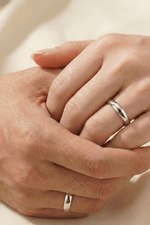 14 Ayar Altın 5 mm Beyaz Alyans on hands showing engagement and commitment in a romantic setting.